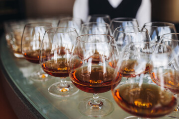 Alcohol setting on catering banquet table, bartender pouring liquor beverages, row line of different colored alcohol drinks on a party, glass of wine, sparkling wine on decorated banquet table event