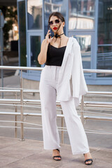 Fototapeta premium Stylish urban woman in striped outfit talking on the phone with confidence