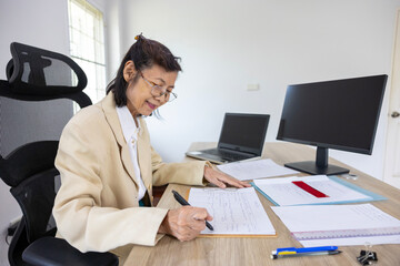 Senior asian businesswoman is working on analyzing information and data in the formal office for education, business, lawyer and accountant