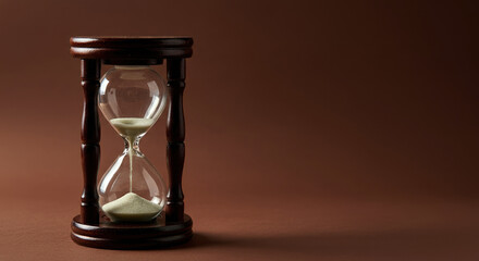 Wooden hourglass with sand falling between bulbs, symbolizing passage of time