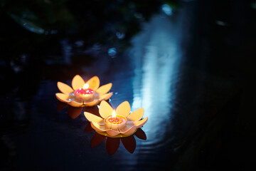 Lotus candles on water in honor of holiday