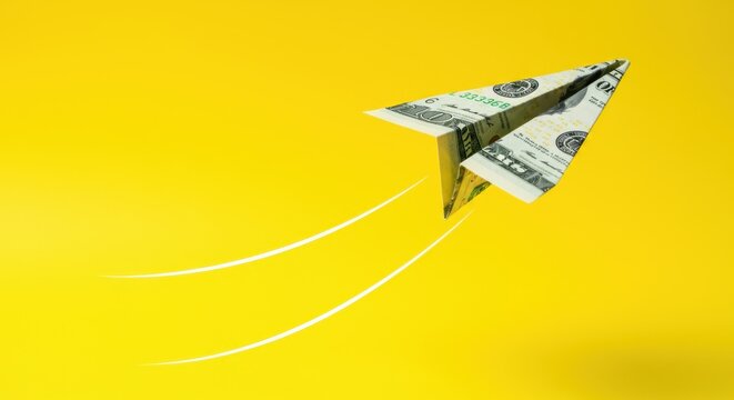 Paper airplane made from money flying on yellow background