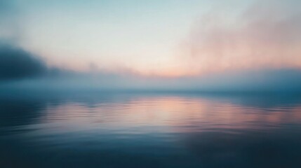 Obraz premium Smoke drifting across a calm lake at dawn, with the mist blending into the early morning fog, creating a tranquil, almost surreal scene.