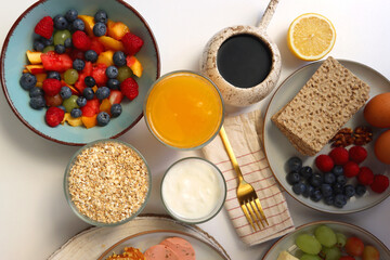 Assortment of various breakfast foods and drinks on the white table. Flat lay.