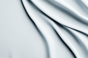 Fototapeta premium Light grey fabric with flowing, smooth folds creating a soft and elegant texture.