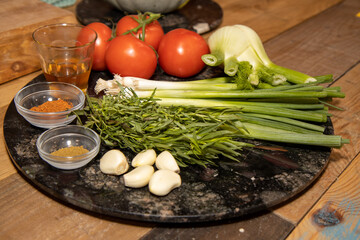 A selection of food ingredients on a wooden kitchen table ready to be cooked