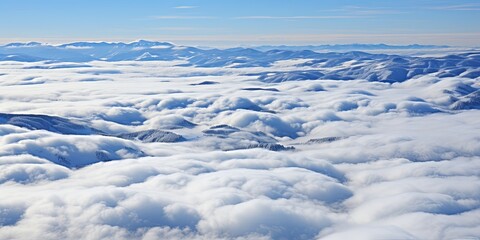 Obraz premium A Serene Expanse of Cottony Clouds Draped Over Snow-Covered Mountains in the Early Morning Light
