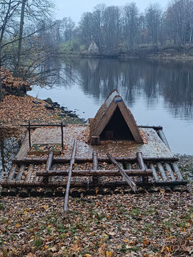 Raft hut on a recreation trail on the river bank at dusk in autumn