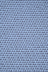 Macro texture of wool blue crocheted sweater as background, close-up of pastel blue crocheted front, blue crocheted back, texture of wool wool, blue crocheted front