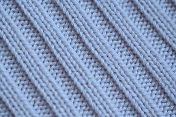 Macro texture of elastic of wool blue crocheted sweater as background, close-up of pastel blue crocheted front, blue crocheted back, texture of wool wool, blue crocheted front