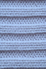 Macro texture of elastic of wool blue crocheted sweater as background, close-up of pastel blue crocheted front, blue crocheted back, texture of wool wool, blue crocheted front