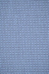 Macro texture of wool blue crocheted sweater as background, close-up of pastel blue crocheted front, blue crocheted back, texture of wool wool, blue crocheted front