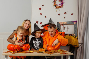 Joyful Halloween celebration, family carving pumpkins at home