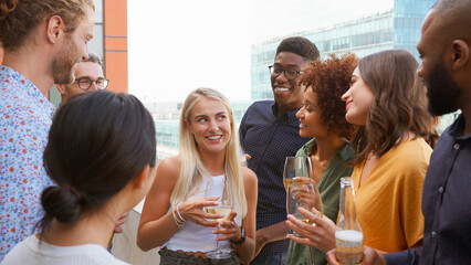 Multi-Cultural Business Team Meeting Outdoors For After Work Drinks On Office Rooftop Or Bar