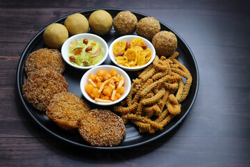 Indian festival food. Diwali Special sweet and salty snacks include Chakli, coconut laddu, besan ladu, poha and sabudana chivda, corn or maka mixture, Anarasa. Diwali Faral from Maharashtra, India.