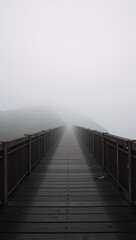 Obraz premium A dimly lit bridge amidst the foggy landscape