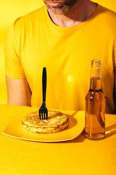 Man in yellow t-shirt having a meal on a yellow background