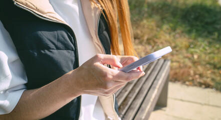 woman in the park with a smartphone in her hands