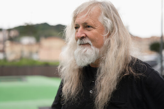 Elderly man with long white hair considering hair donation