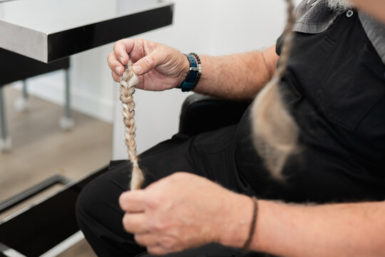Person holding a freshly cut braid for hair donation