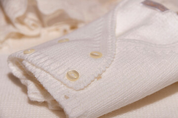 Fragment of preparation of clothes for baby baptism with wool jacket