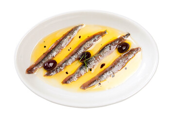 Overhead shot of a white plate with anchovies and black olives with rosemary in their oil
