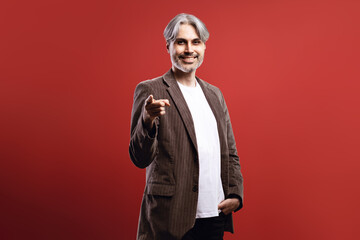 man in striped blazer smiling, pointing forward