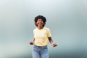 Dancer afro woman listening music on bright blue background