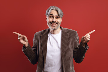 man in striped blazer smiling, pointing to both sides