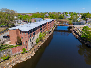 Fototapeta premium Sayles Street Bridge and Glenark Mills building on Blackstone River aerial view in downtown Woonsocket, Rhode Island RI, USA.