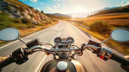 Naklejka premium A motorcycle speeds down an open road, the horizon widening ahead with mountains and countryside bathed in warm sunlight.