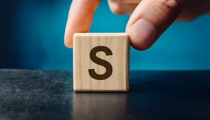 Naklejka premium Hand hold wooden cube with letter s from idea concep