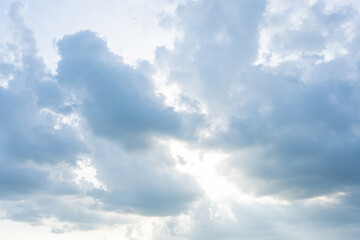 Fluffy white clouds drift across a bright blue sky, casting soft shadows on the Earth