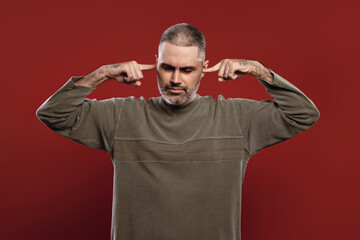 Fototapeta premium man covering his ears with his fingers