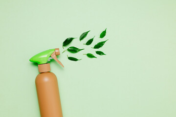 Bottle with cleaning spray on podium with green leaves on green background top view. Eco friendly...