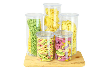 Storing different types of pasta at home. Varieties of multi-colored pasta in glass containers. Types of uncooked pasta. Isolate on a white background.