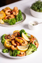 Shrimp and vegetables cooked in the oven for a healthy lunch on a white table