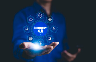 Smart industry 4.0 technology concept. A person holding digital interface with glowing icons representing Industry 4.0, IoT, AI, automation, and smart manufacturing technologies. Factory modern,