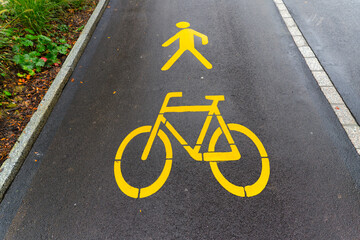 Obraz premium Yellow road marking of combined pathway for pedestrians and cyclists at Swiss City of Zürich on a rainy autumn day. Photo taken October 8th, 2024, Zurich, Switzerland.
