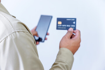 A person holding credit cards and a phone, ready for a transaction or payment.