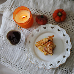 Pumpkin pie on a plate, cup of tea, candle. Autumn mood