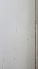 Cracks inside the building. Cracks on the walls inside the room near the house pillars, Building problems and solutions concept. Paint peeling off the walls. Damage from subsidence, vibrations.

