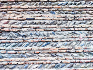 Textured wall of interwoven bricks and stones displayed in a rustic style