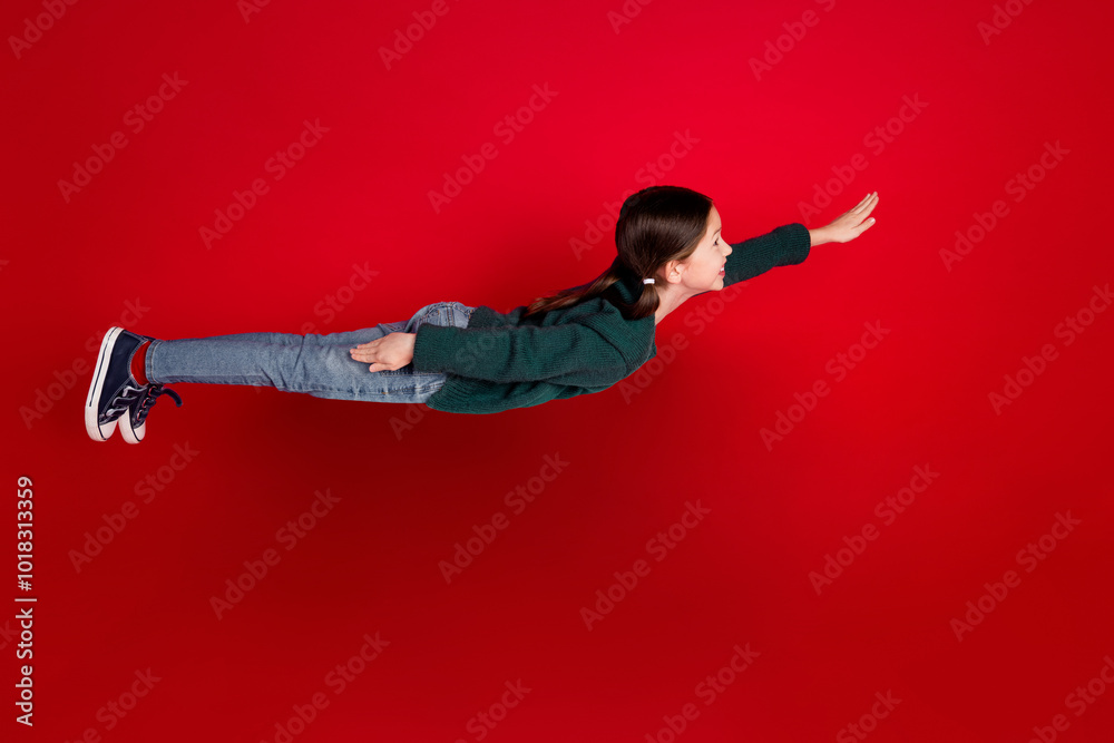 Poster Full size photo of pretty small girl flying superhero wear green christmas outfit theme party on red color background