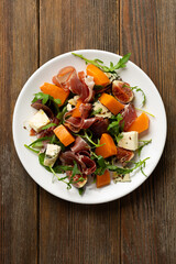 Jamon blue cheese and figs butternut pumpkin salad rocket on white plate