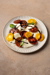 Caprese salad with sliced heirloom tomatoes and burrata cheese  close up