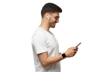 Side shot of young man in white t-shirt, wearing smartwatch and wireless earphones, holding phone and smiling at screen