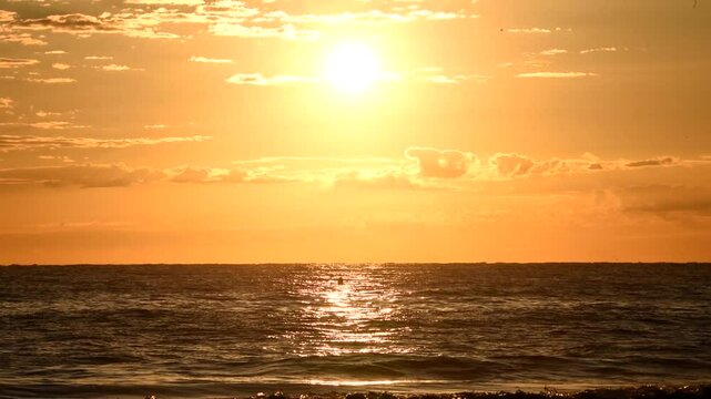 A beautiful sunrise over the sea. The morning sun illuminates the sea. Sun reflections in the water - Extreme heat and global warming effect El Nino event