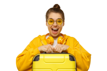Happy excited girl wearing hoodie, yellow colored glasses and headphones around neck, holding travel suitcase, feeling ready for flight