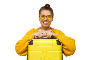 Young smiling woman in yellow hoodie and colored glasses holding travel suitcase, willing to go on trip